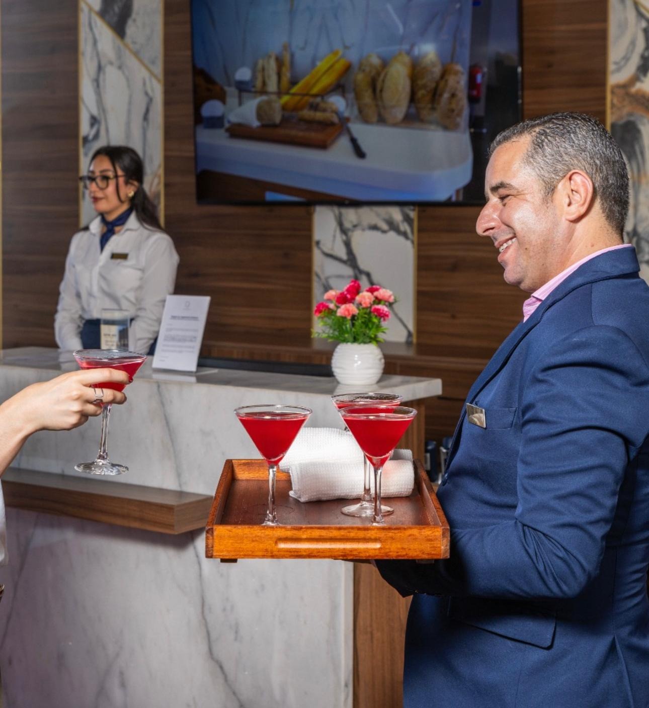 Un membre du personnel de l'hôtel apporte des cocktails de bienvenue