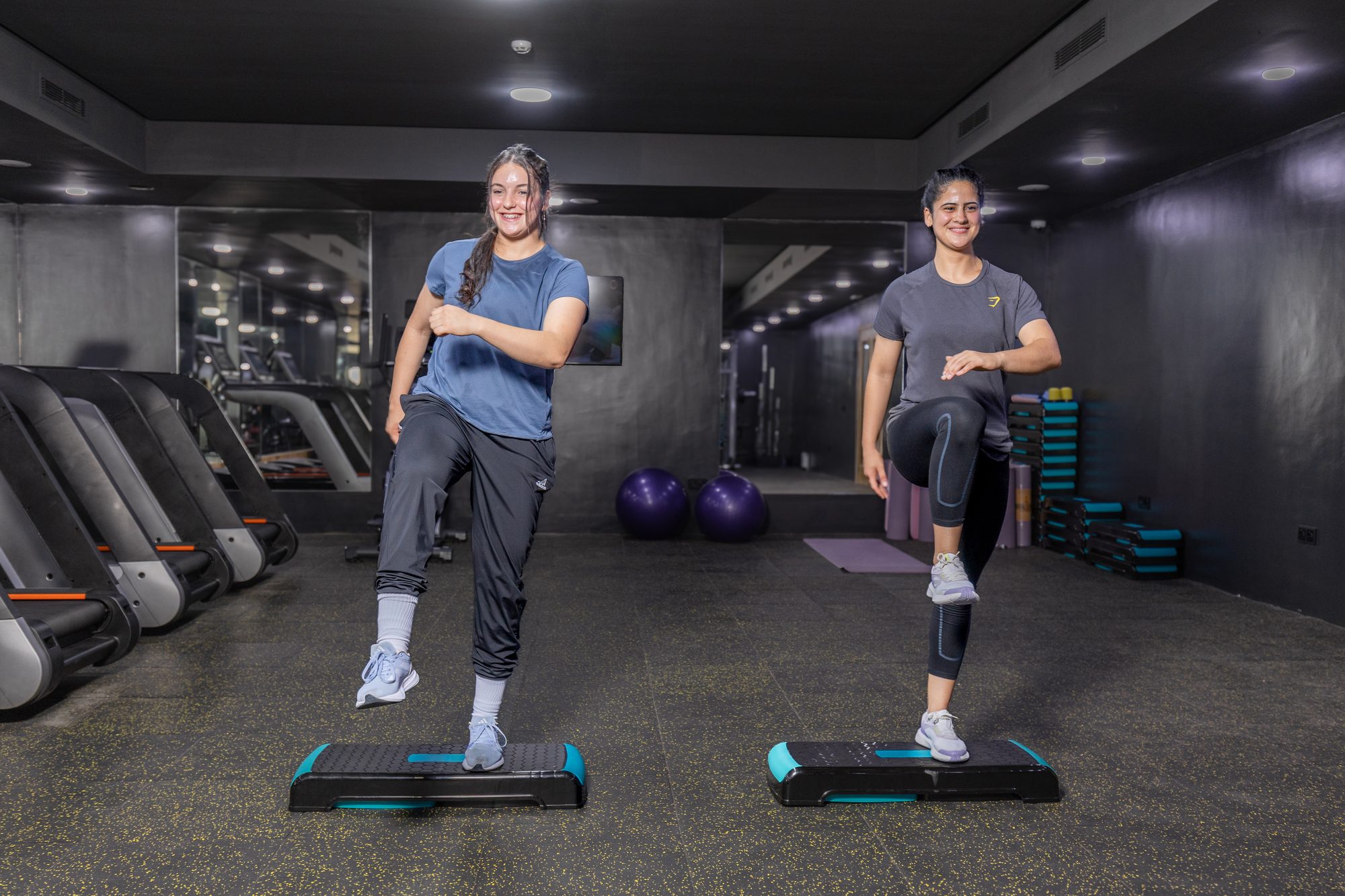 Deux clientes suivent une séance de step à la salle de fitness