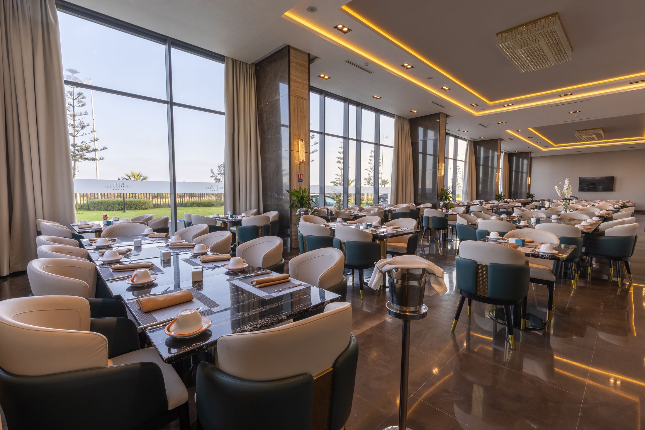 La salle du restaurant Le Méditerranéen et ses grandes baies vitrées